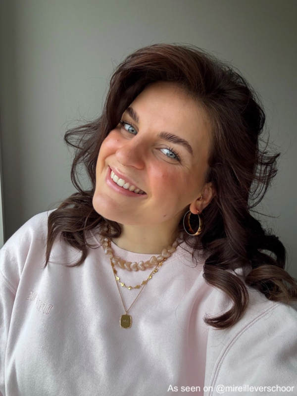 Influencer draagt beige hartjes kralenketting