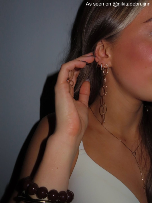 Influencer draagt gouden lange oorbellen ketting