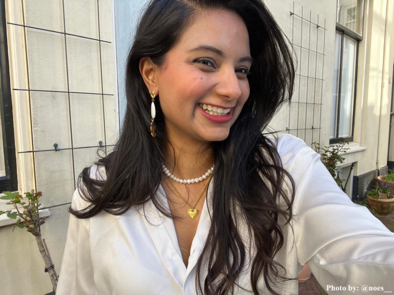 Influencer met witte druppel bloem oorbel.