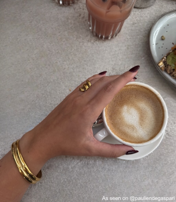 Influencer met gouden bangle met koffie