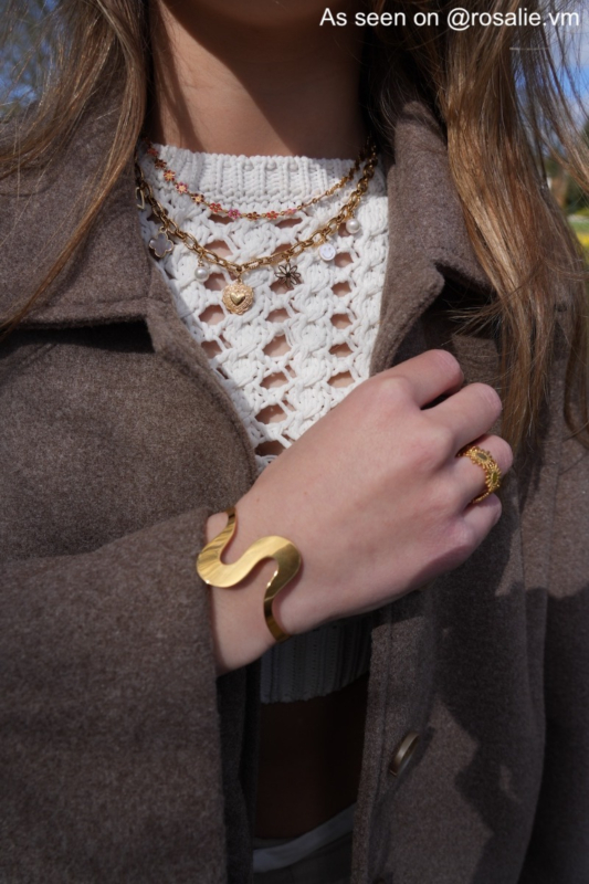 Influencer met gouden bangle, ring en 2 kettingen