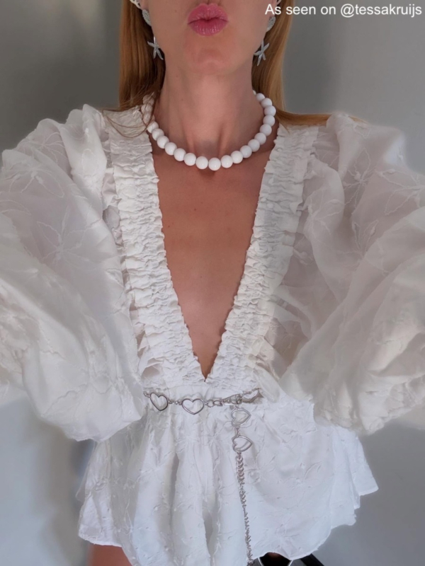 Influencer draagt witte kralen ketting