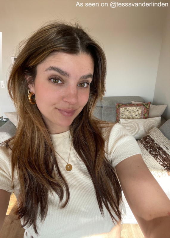Influencer draagt 1 gouden initial ketting en gouden oorbellen
