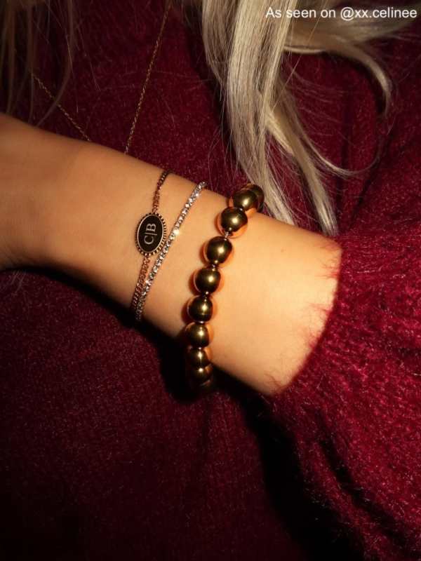 influencer draagt armparty met vintage initial armband goudkleurig
