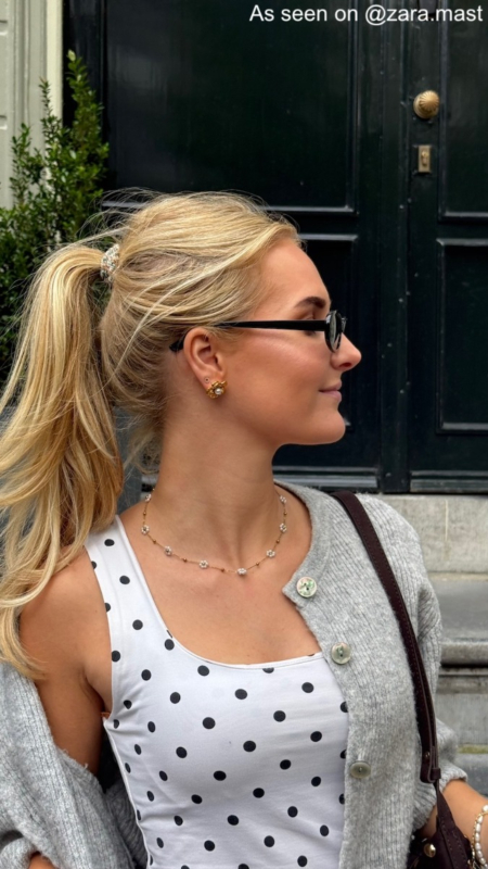 Influencer draagt gouden bloem oorbel 