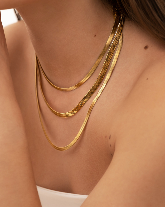 Model draagt mix van gouden kettingen