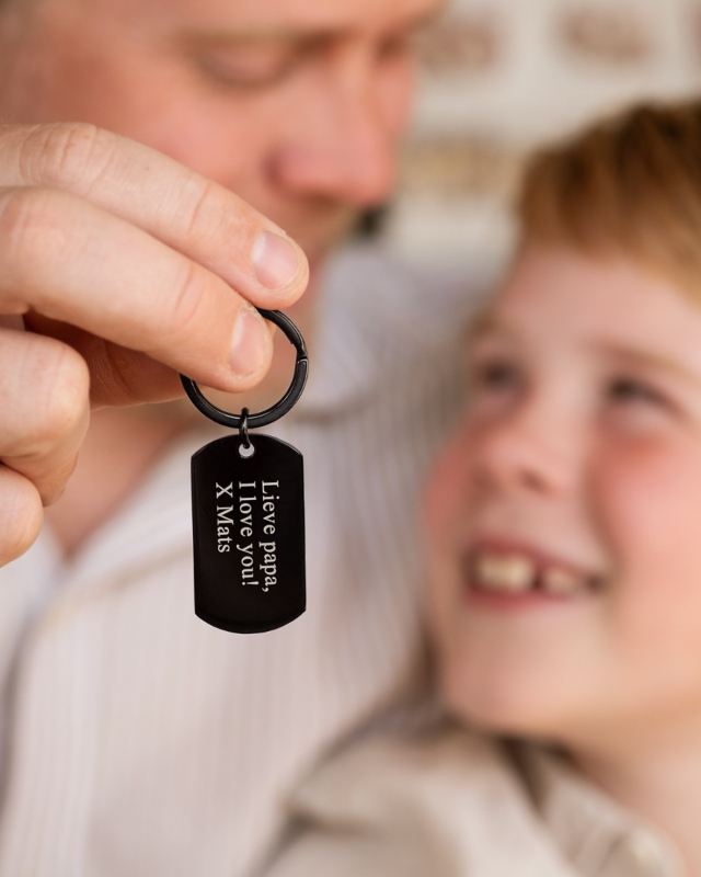vader en zoon met zwarte sleutelhanger met gravering voor papa