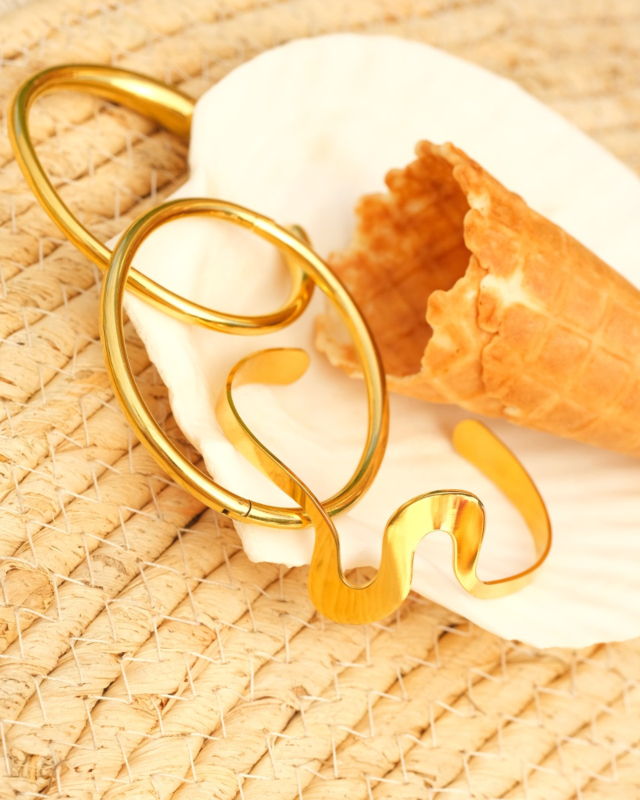 gouden bangles op witte schelp