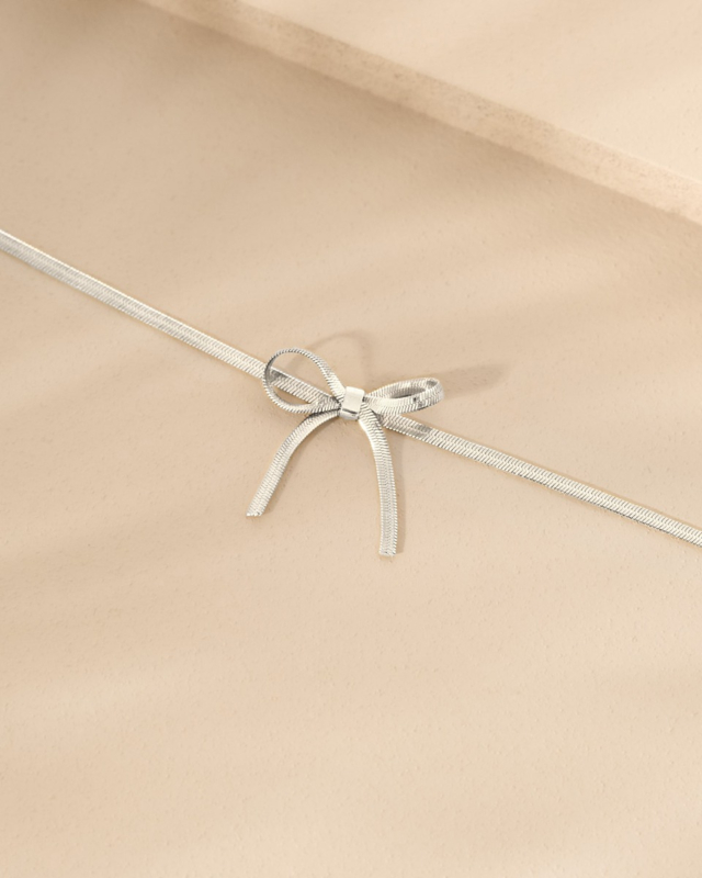 Zilveren armband met strikje op stenen ondergrond