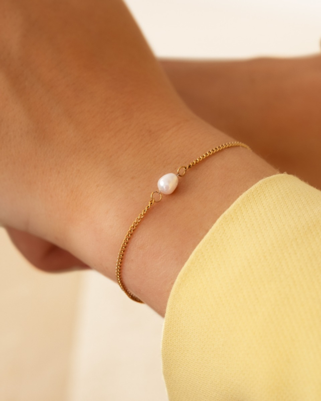 subtiel gouden parel armbandje met gele blazer