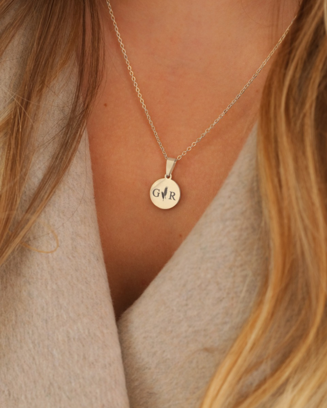 zilveren ketting met twee letters en granen