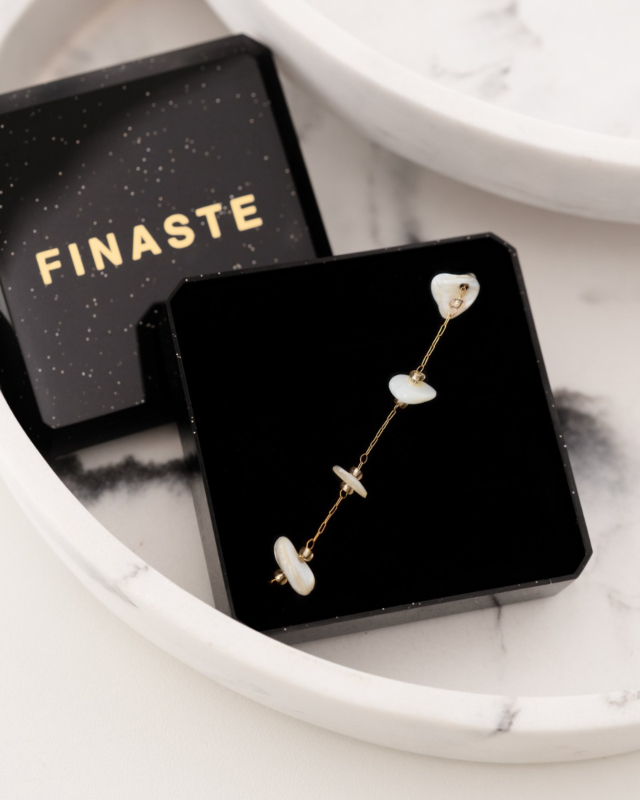 gouden armbandje met beige steentjes in sieradendoosje