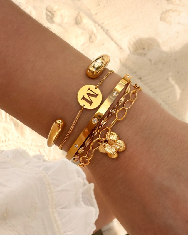 gouden armbanden combinatie op het strand