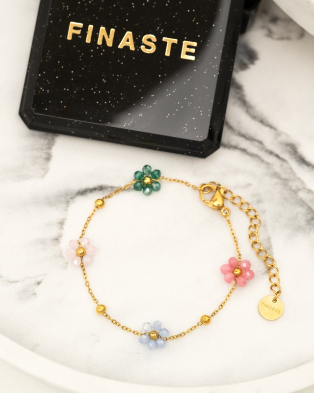 gouden armband met gekleurde bloemetjes met een sieradendoosje