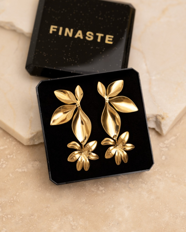 sieradendoosje met bloem oorbellen op beige steen