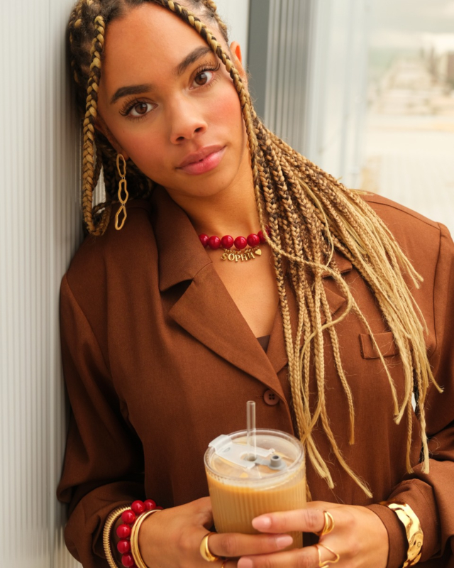 Model draagt gouden en rode sieraden