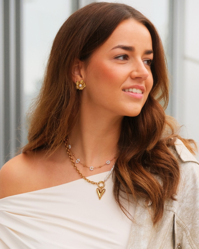 Model draagt parel sieraden goud