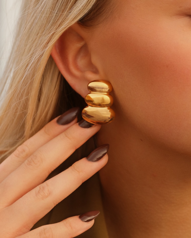 Model draagt gouden stud oorbellen