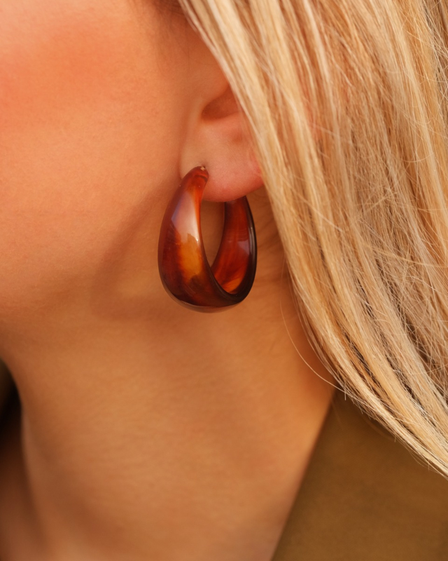 Model draagt bruine oorringen