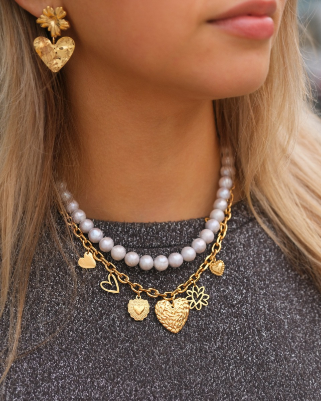 Model draagt necklaceparty met parels en hartjes