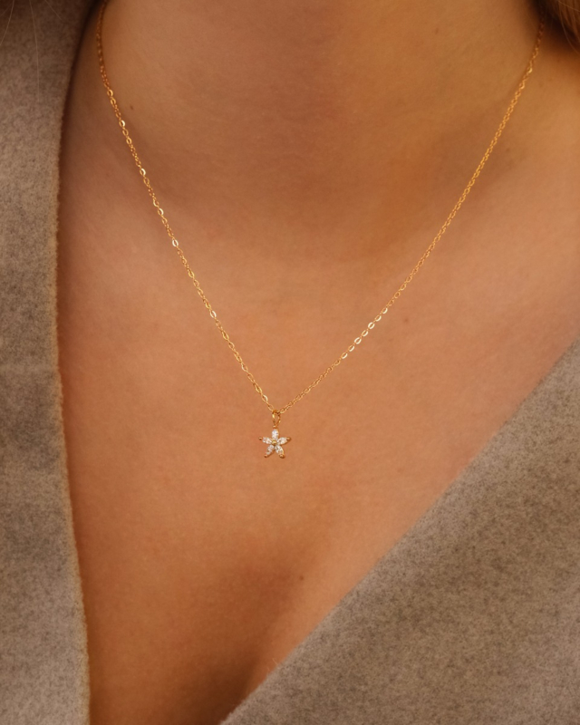 Model draagt gouden sparkle flower ketting