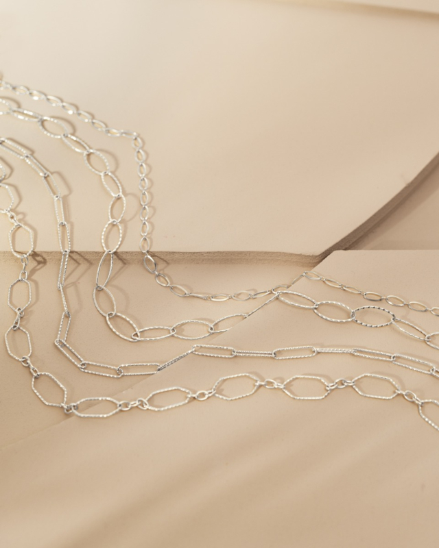 zilveren lange chain kettingen op beige ondergrond