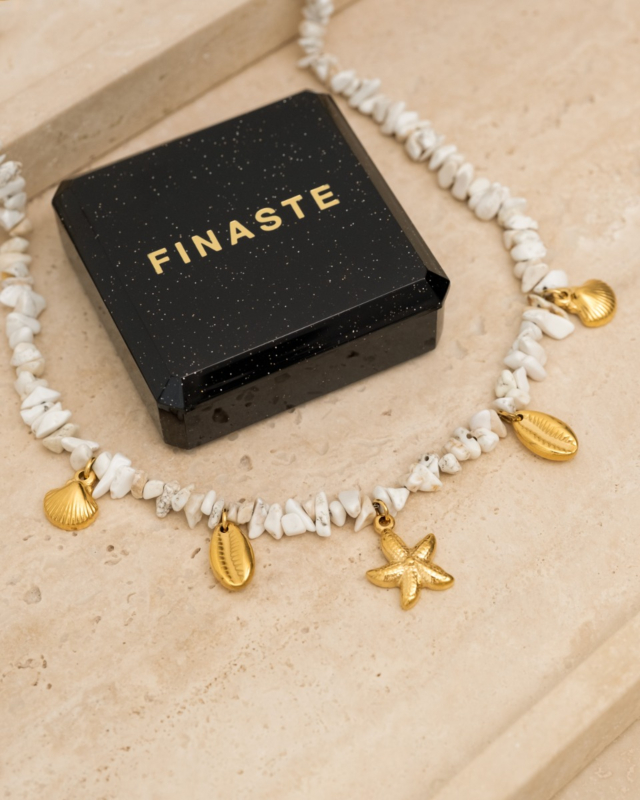 witte steentjes ketting met gouden bedeltjes en sieradendoosje