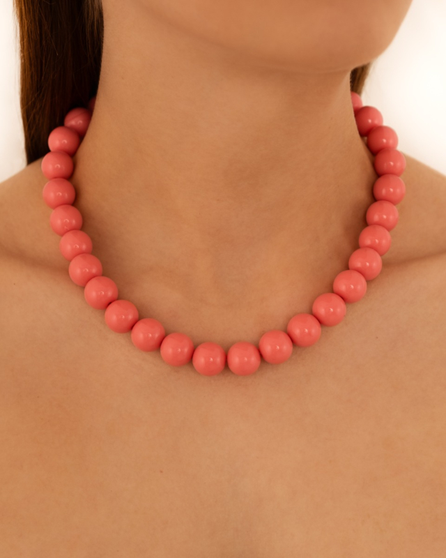 Model draagt roze kralen ketting