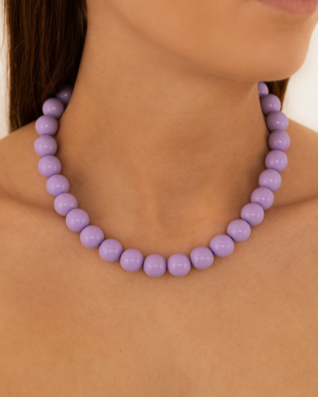 Model draagt paarse kralen ketting