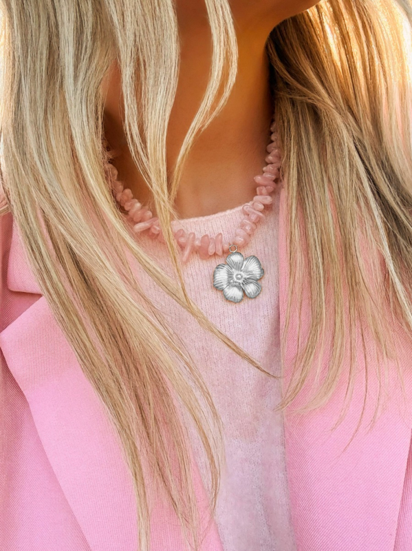 Model met roze kralen ketting met zilveren bloem bedel