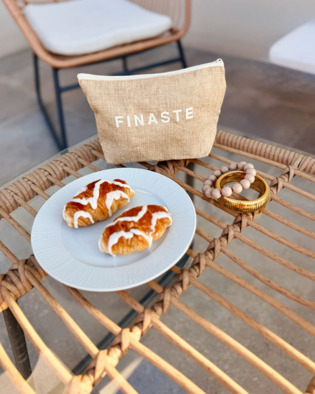 2 armbandjes op een stoel met croissantjes en toilettasje