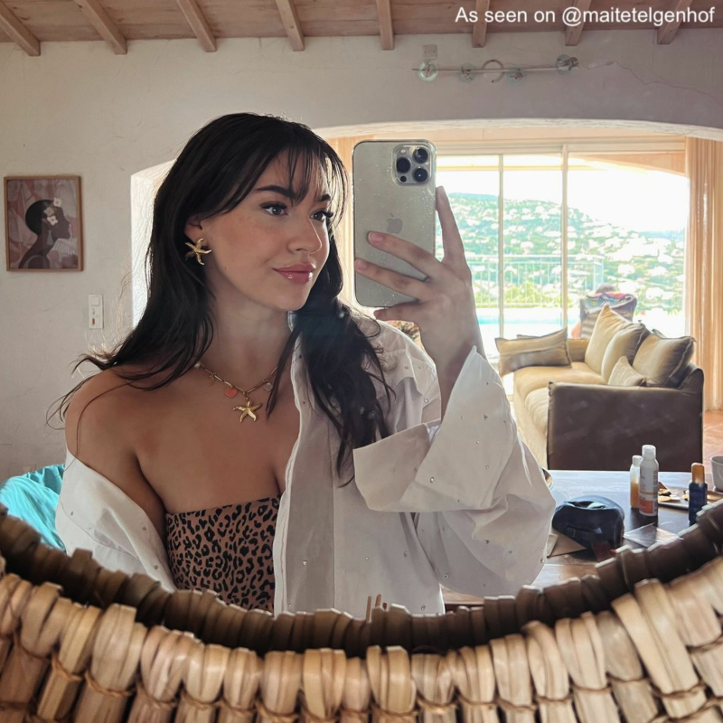 Influencer draagt gouden zeester oorbellen en bedelketting