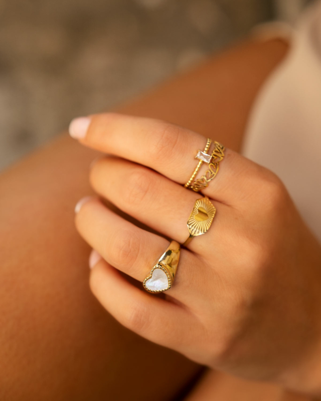gouden ring met steentje om hand