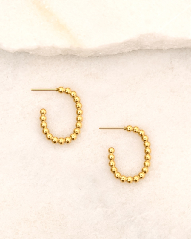 Gouden oorringen op marmer