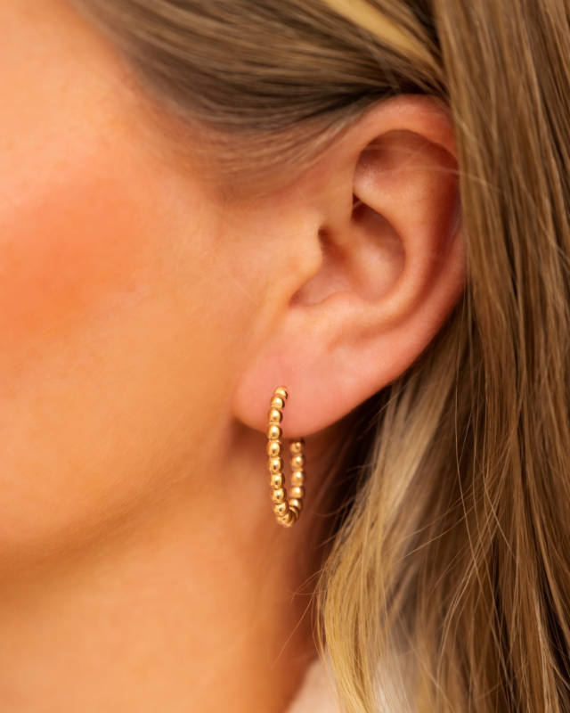 Gouden oorringen in oor