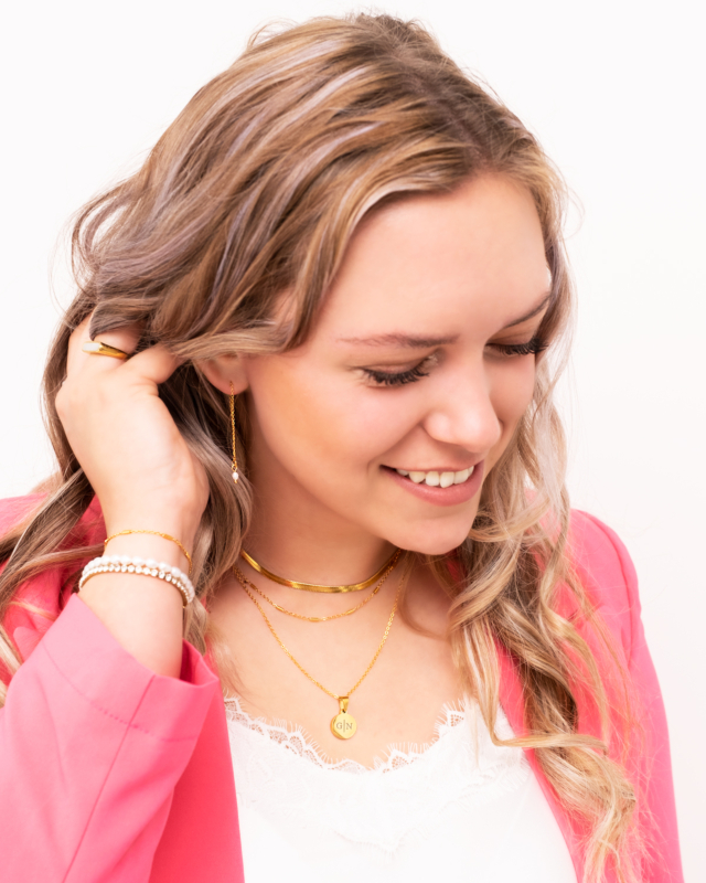 Vrouw draagt mix van gouden sieraden