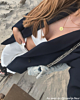 Gouden initial ketting met munt bij zwarte blazer