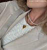 Influencer draagt 2 gouden kettingen en 1 parelketting