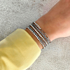 Trendy armbanden in het zilverkleurig om de pols van het model