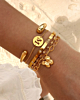 gouden armbanden combinatie op het strand