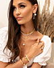 Model draagt gouden en witte sieraden look