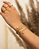 Gouden armbanden look bij model