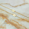 Verschillende gouden armbandjes op marmeren plaatje