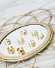 Gouden ear cuffs op een spiegel
