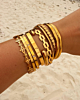 gouden armparty van bangles op het strand