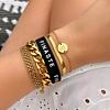 Zwart armbandje met tekst Finaste met gouden armbanden