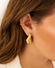 Model draagt gouden ear cuff hartjes