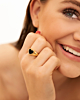 goudkleurige ring met zwart hartje om hand van model