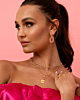 model draagt gouden sieraden met roze details