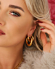 Model draagt oorbellen set goud